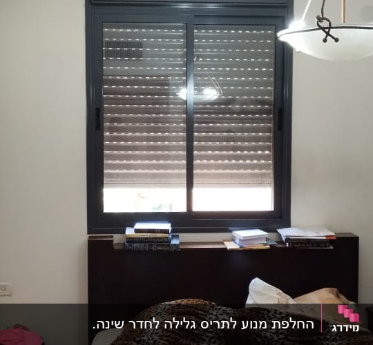תריסים סגורים בחלון גדול עם מסגרת כהה
